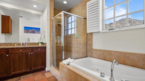 a bathroom with a tub and a shower and a sink at LV105 Upstairs 1 Bedroom Overlooking the Pool in La Quinta