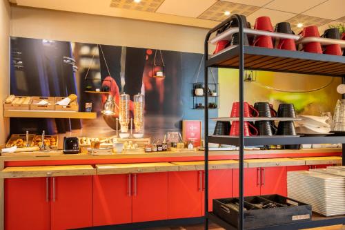 a kitchen with red cabinets and a red counter top at ibis Paris Creteil in Créteil