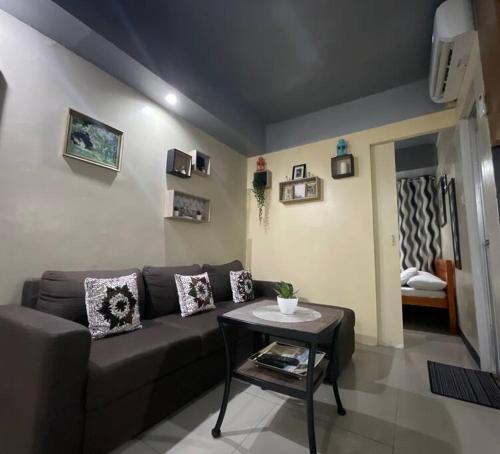 een woonkamer met een bank en een tafel bij Antipolo Staycation & Transient Affordable Condo Unit By Myra in Antipolo