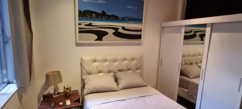 1 dormitorio pequeño con 1 cama y una foto en la pared en The best Copacabana Luxury Design 3 Bedroom room 3 bathroom 85 inch cinema tv top location, en Río de Janeiro