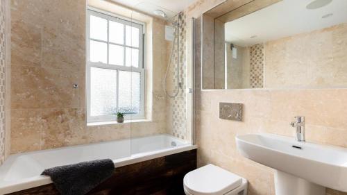 a bathroom with a tub and a sink and a toilet at HipNautic, Mevagissey, Sleeps 6 in Mevagissey