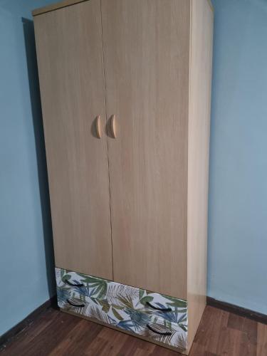 um armário de madeira com uma porta num quarto em Habitación2 piso lavanda em Vilhena