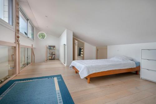 a bedroom with a bed and a blue rug at Maison a trois cent metres de la plage in Saint-Nazaire
