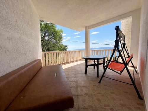 a room with a camera and a table on a balcony at Seaview apartment Mimice in Mimice