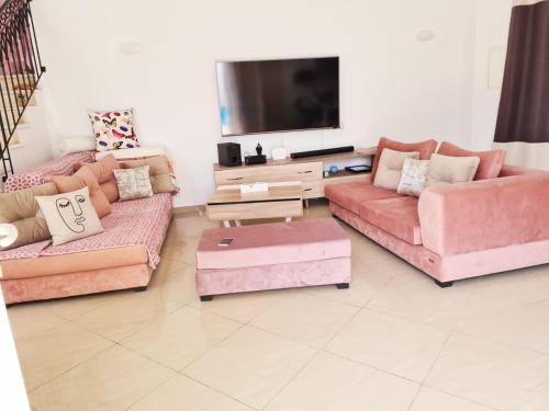 uma sala de estar com 3 sofás e uma televisão de ecrã plano em DAR ALMATY em Houmt Souk
