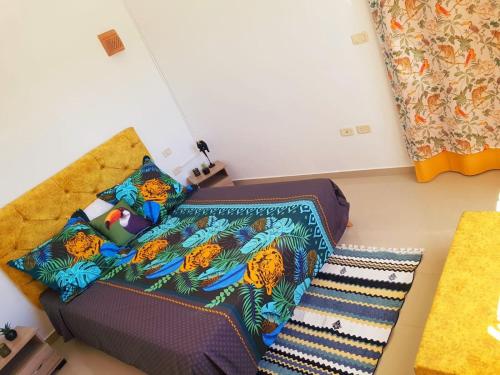 um pequeno quarto com uma cama e um sofá em DAR ALMATY em Houmt Souk