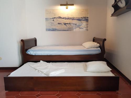 two twin beds in a room with a painting at Sines Ocean View Apartment in Sines
