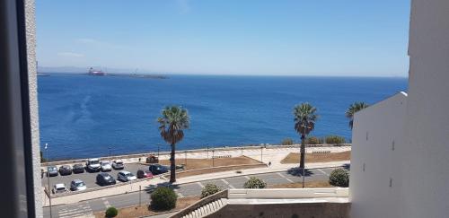 a view of the ocean from a building with palm trees at Sines Ocean View Apartment in Sines