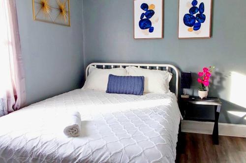 a bedroom with a white bed with a blue wall at Entire Studio Apartment #2/Minutes to Downtown Indianapolis in Indianapolis