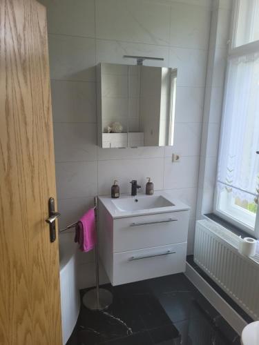 a white bathroom with a sink and a mirror at Ferienwohnung Rote-Villa 2 in Marienberg