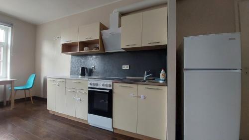a kitchen with white cabinets and a white refrigerator at Comfy room near city centre in Tallinn
