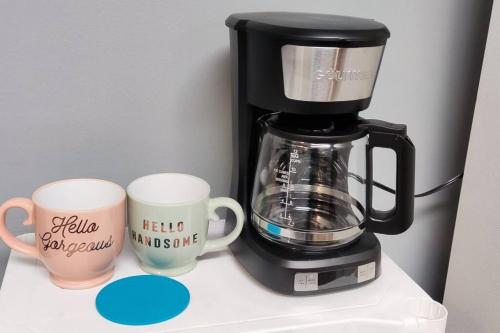 a coffee maker and two coffee cups on a counter at Entire Studio Apartment #2/Minutes to Downtown Indianapolis in Indianapolis