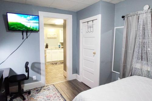 a bedroom with a bed and a television on a wall at Entire Studio Apartment #2/Minutes to Downtown Indianapolis in Indianapolis