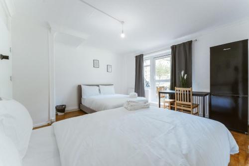 a white bedroom with a large bed and a window at Holloway Road Double rooms - 5 in London