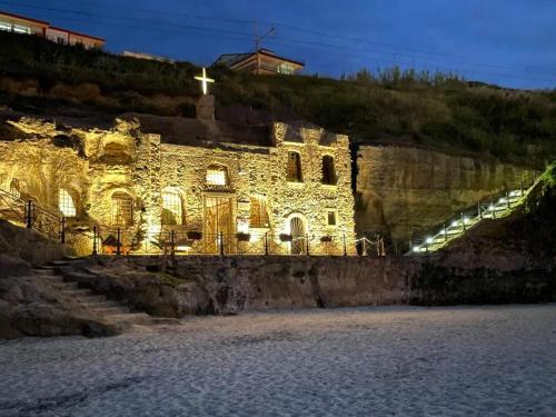 an old stone building with a cross on a hill at B&BUrszula Gizzeria Lido in SantʼEufemia Lamezia