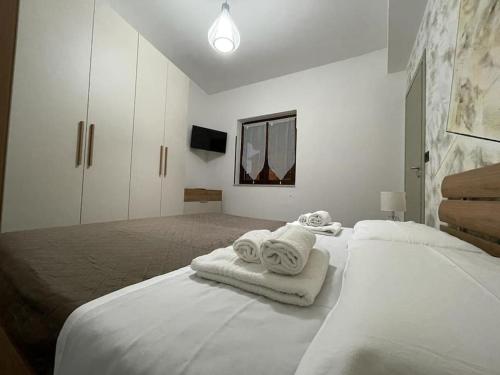 ein weißes Schlafzimmer mit einem Bett mit Handtüchern darauf in der Unterkunft B&BUrszula Gizzeria Lido in SantʼEufemia Lamezia