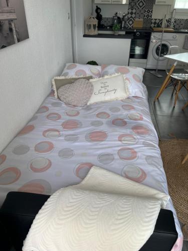 - un lit avec des points de polka dans une chambre dans l'établissement Valensole, à Valensole