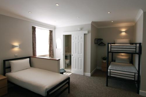 a bedroom with a bed and a bunk bed at Lords Hotel in London