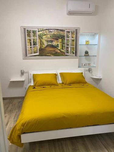 Cama amarilla en habitación blanca con ventana en Exclusive Mood Apartment en Roma
