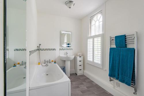 Un baño blanco con bañera y lavabo. en Lookout Post by Bloom Stays, en Folkestone