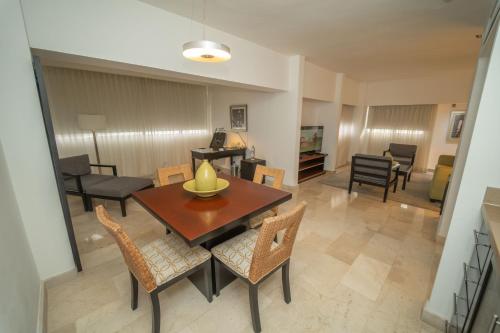 a living room with a dining room table and chairs at Radisson Hotel Santo Domingo in Santo Domingo
