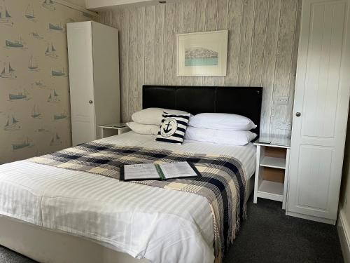 a bedroom with a bed with two pillows on it at Shellseekers Guest House in Looe