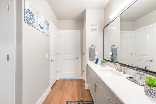 a white bathroom with two sinks and a large mirror at Elegant & Luxurious Modern Apartment with Southern Charm in Fort Worth