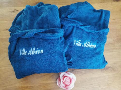 dos bolsas azules sentadas en una mesa con una rosa rosa en Villa Athéna,séjour bien-être et éthique, en Meuvaines