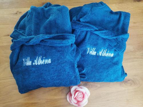 Dois sacos azuis sentados numa mesa com uma rosa rosa em Villa Athéna,séjour bien-être et éthique em Meuvaines