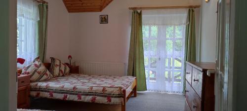 a bedroom with a bed and a dresser and a window at Casa Bănucu in Satu Mare