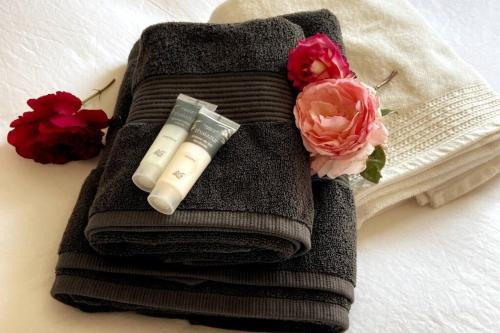Una toalla con una botella de jabón y flores en una cama en Mas Provençale au calme Piscine, en Vacqueyras