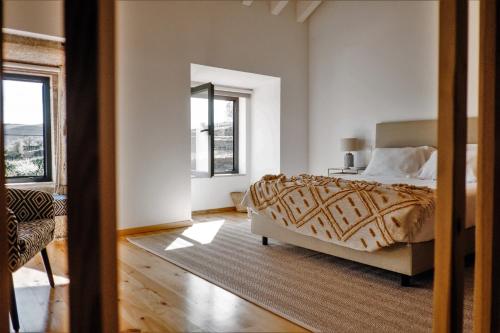 a bedroom with a bed and a large window at Casa do Santo - Wine & Tourism in Provesende