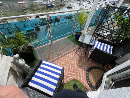 a balcony with chairs and a pool on a ship at Shellseekers Guest House in Looe