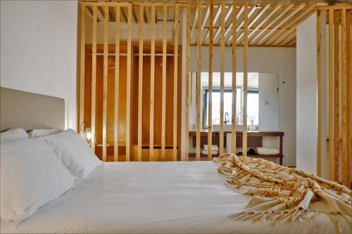 a bedroom with a large white bed and a mirror at Casa do Santo - Wine & Tourism in Provesende