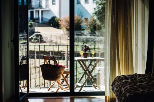 a room with a table and a balcony with a view at Casa do Santo - Wine & Tourism in Provesende