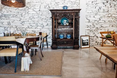 a dining room with a table and chairs and a stone wall at Casa do Santo - Wine & Tourism in Provesende