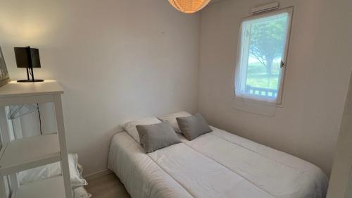 une petite chambre avec un lit et une fenêtre dans l'établissement Appartement 2 pièces en rez-de-chaussée dans résidence avec accès direct à la plage, à Cabourg