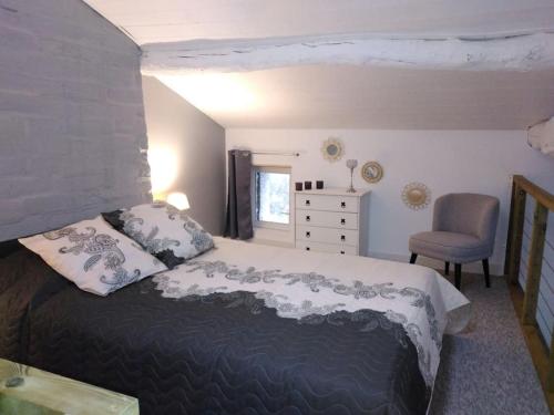 Gîte des Bujours في Saint-Bris-des-Bois: غرفة نوم بسرير كبير وكرسي