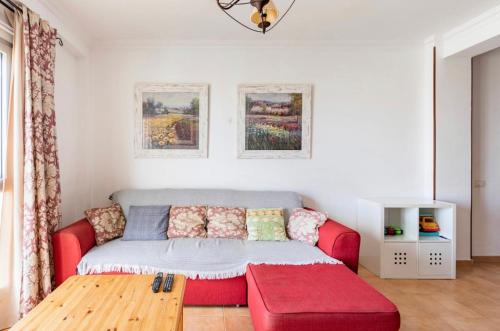 a living room with a red couch and a red ottoman at Buddha penthouse solarium+pool in Gáldar
