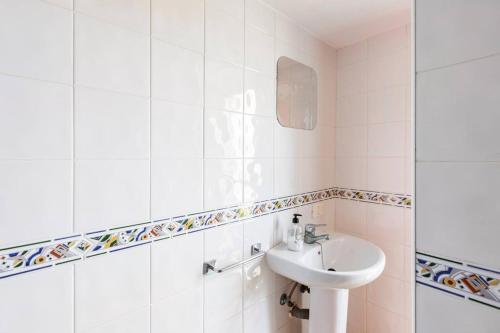 a white bathroom with a sink and a mirror at Buddha penthouse solarium+pool in Gáldar