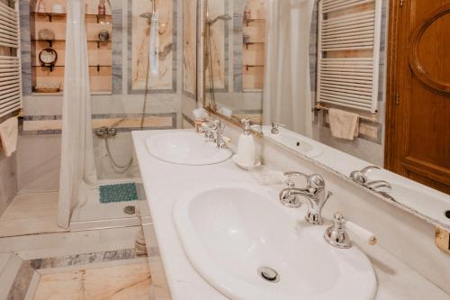a white bathroom with a sink and a mirror at Villa Luigi XVI in Taranto