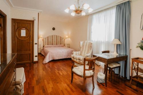 a bedroom with a bed and a desk and a chair at Villa Luigi XVI in Taranto