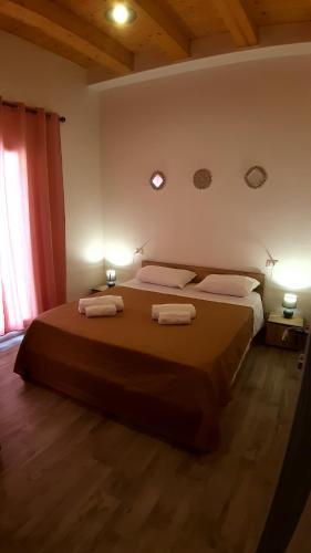 a bedroom with a large bed with two towels on it at Casanuova Flat, City Center in Olbia