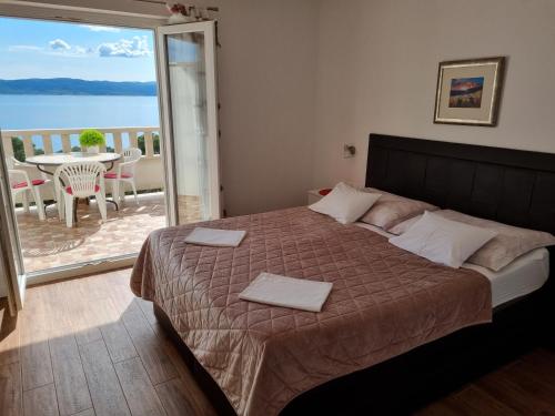 a bedroom with a bed with a view of the ocean at Apartmani BELVEDERE in Brela