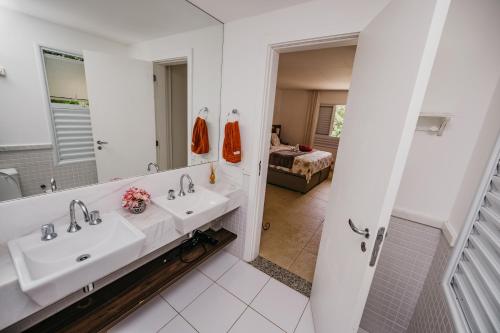 a bathroom with two sinks and a mirror at Beach House Sauípe in Costa do Sauipe