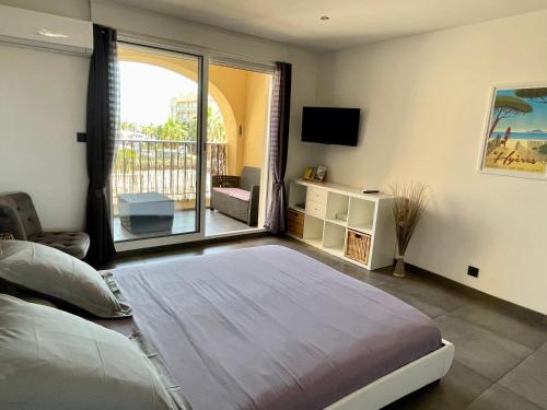 a bedroom with a large bed and a balcony at Le Port Plage Studio tout confort Terrasse Clim in Hyères