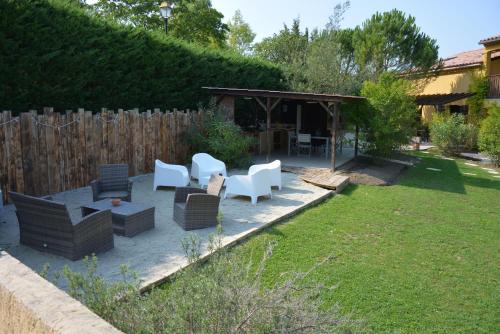 eine Terrasse mit Stühlen und einem Pavillon im Hof in der Unterkunft Le Jardin des Gorges in Belvianes-et-Cavirac
