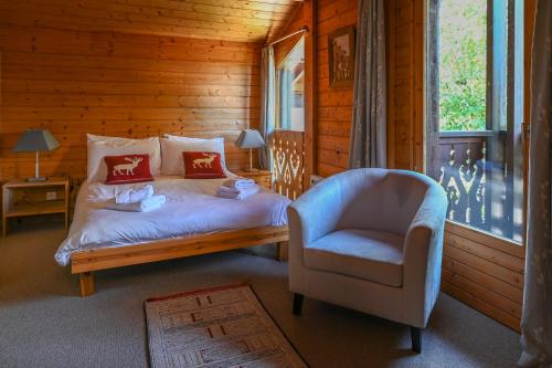 ein Schlafzimmer mit einem Bett und einem Stuhl in der Unterkunft Chalet de Vantaa in Les Gets