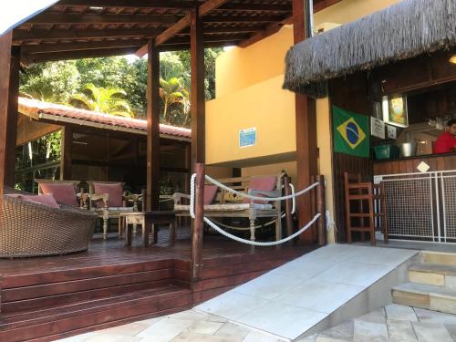 a resort with a porch with chairs and a hammock at Riviera de São Lourenço Amarilis 302 in Bertioga