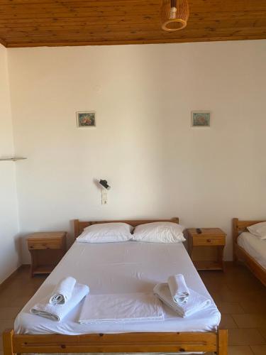 a bedroom with a white bed with towels on it at Artemis Hotel-MeRaki Restaurant in Frangokastello